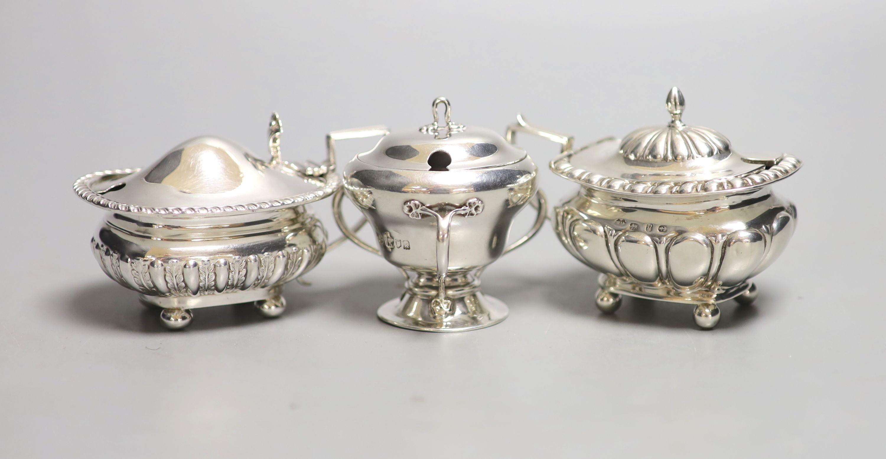 Three assorted 20th century silver mustard pots including Art Nouveau, Birmingham, 1909, tallest 6cm.